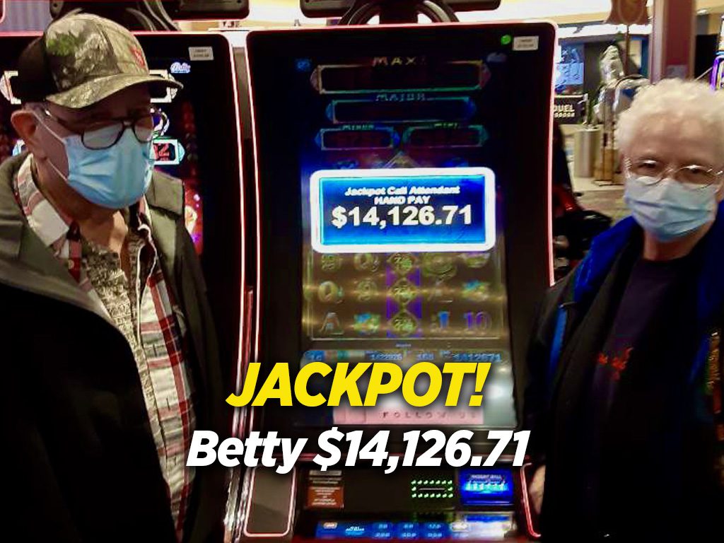 A man standing next to a slot machine.