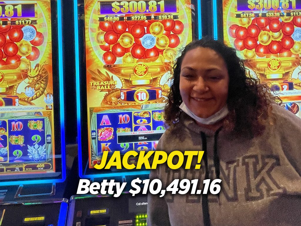 A woman standing in front of slot machines.