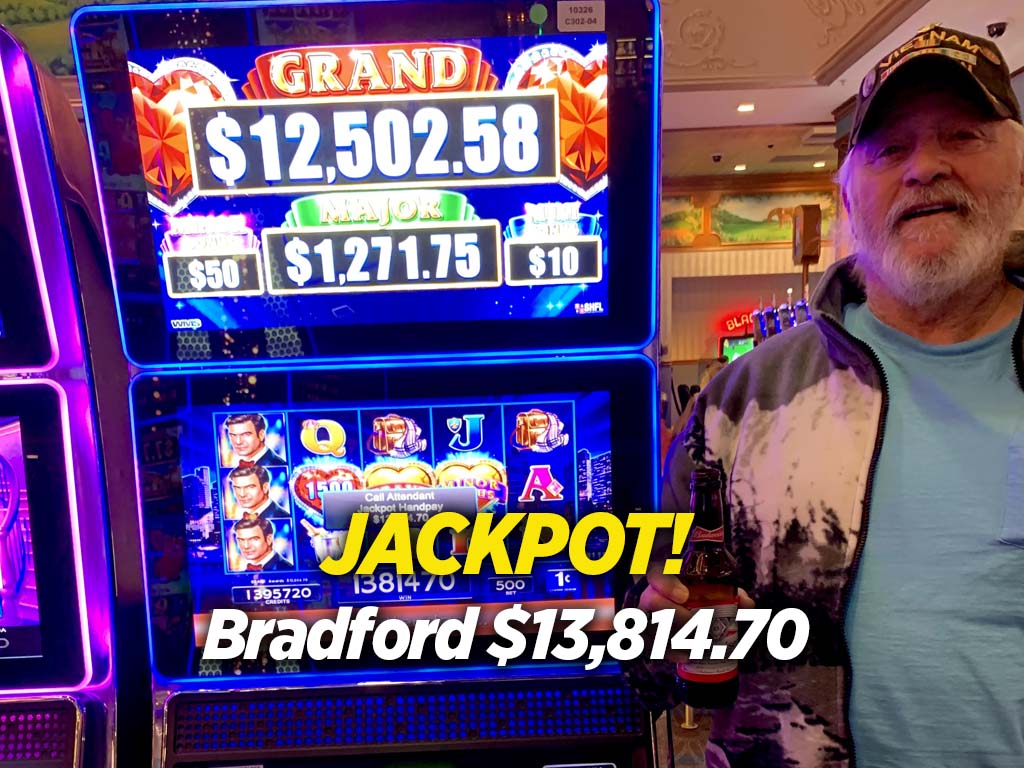 A man standing next to a slot machine.