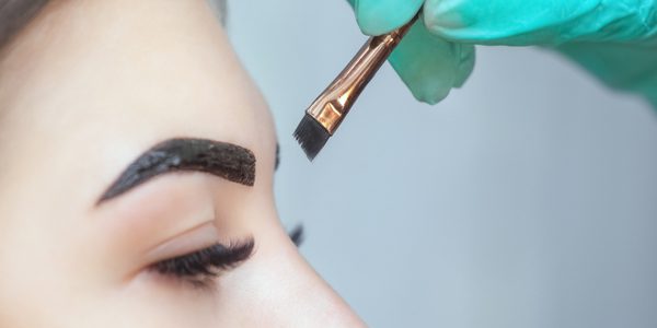 A person with their eyes closed and a brush in hand.
