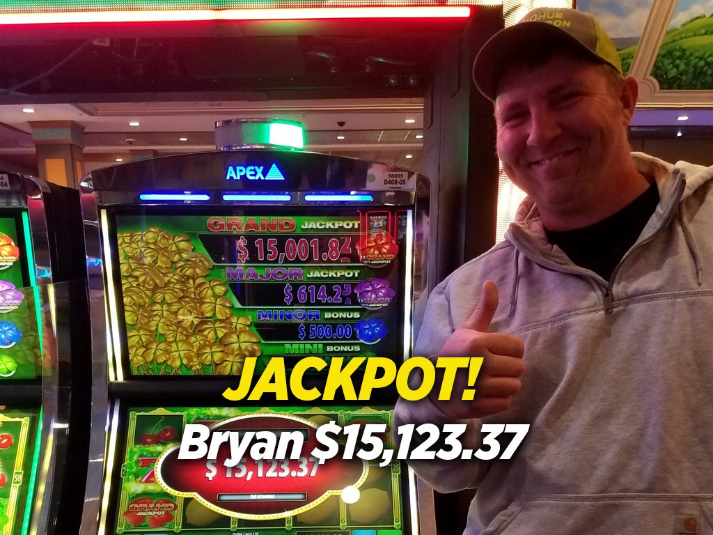 A man standing next to a slot machine.