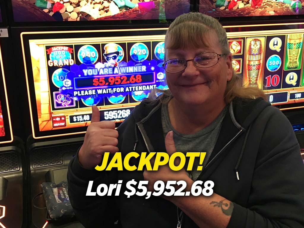 A woman is smiling in front of a slot machine.