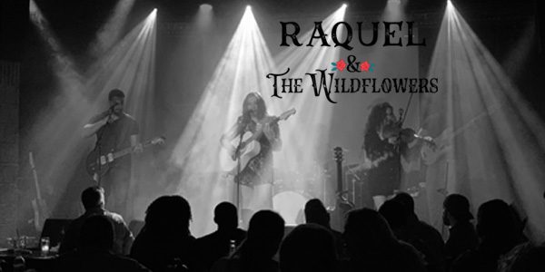 A band is performing on stage with the words raquel and the wildflowers written above them.