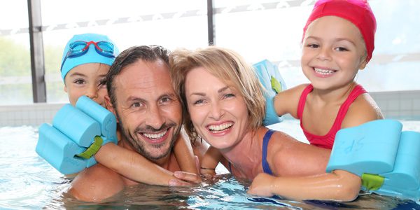 A family is swimming in the pool together.
