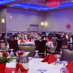 A banquet hall with tables and chairs set up for dinner.