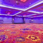 A large room with purple lighting and carpet.