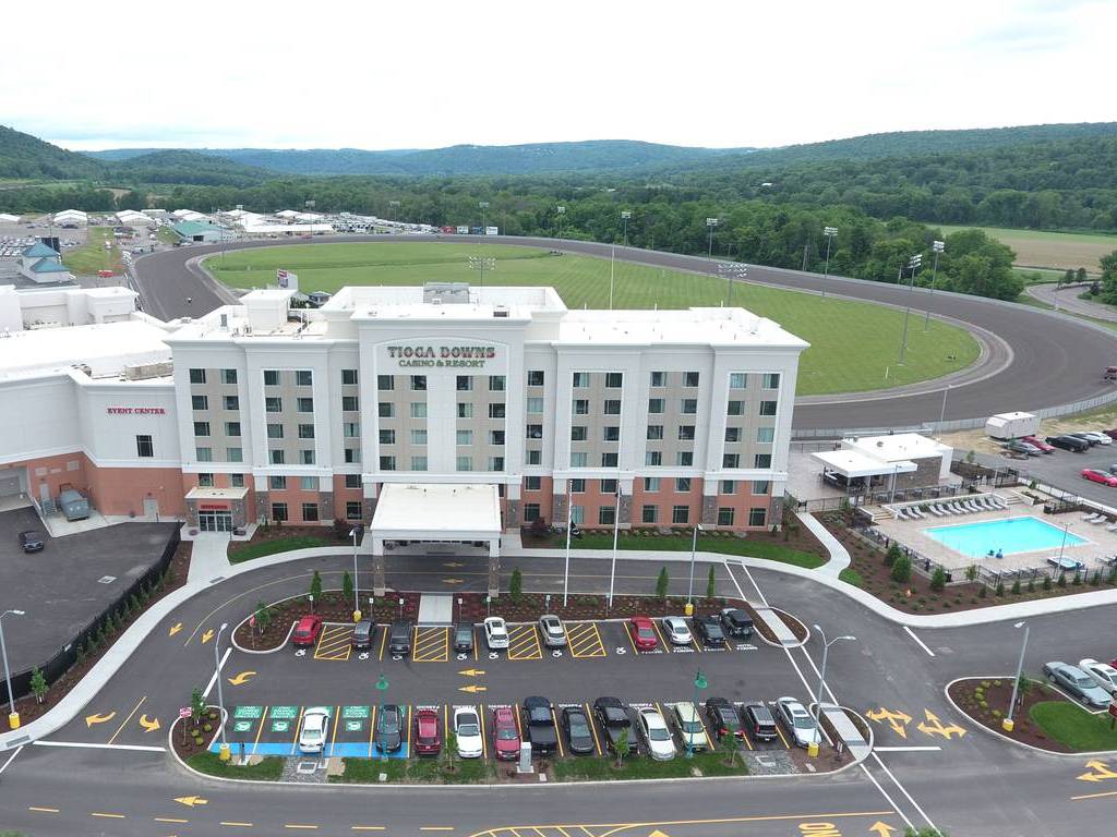 A hotel with cars parked in front of it.