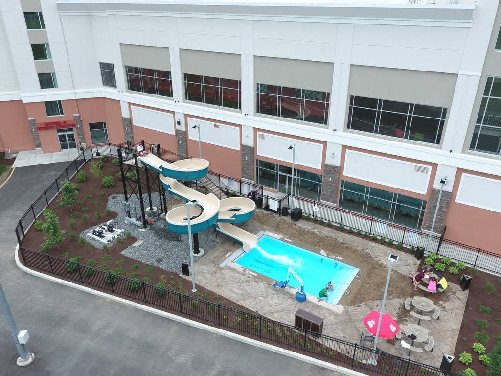 A view of an outdoor pool and water slide.