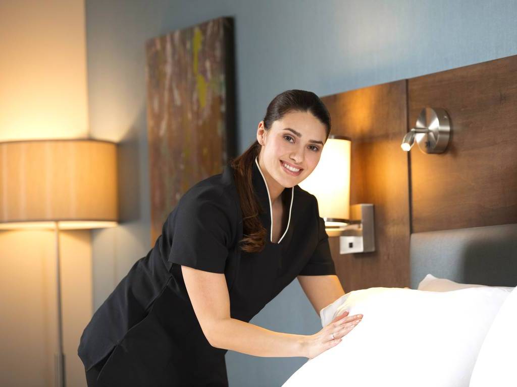 A woman in black shirt holding white sheet.