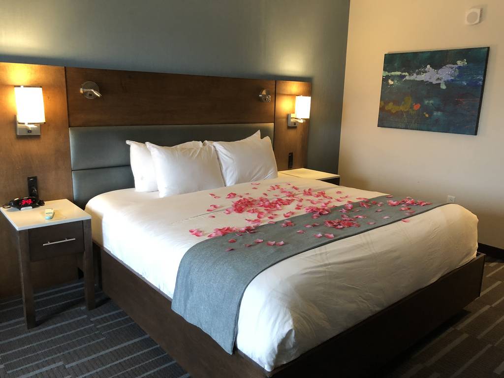 A bed with petals on the bottom of it
