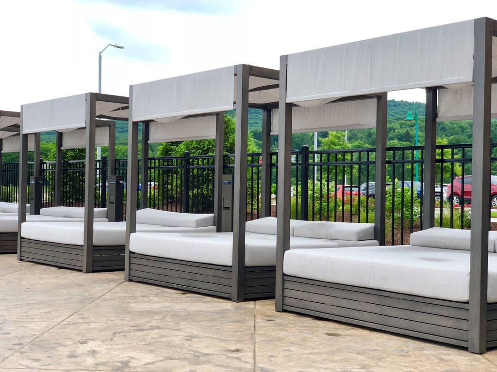 A row of outdoor beds with white covers.