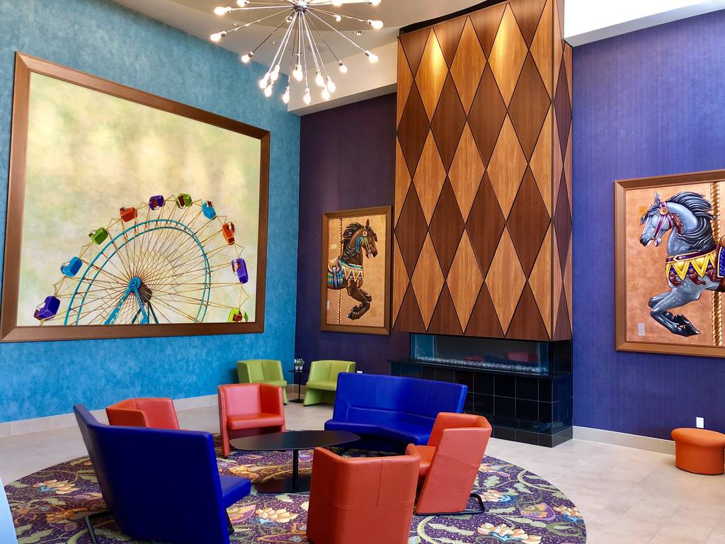A room with many chairs and a painting on the wall