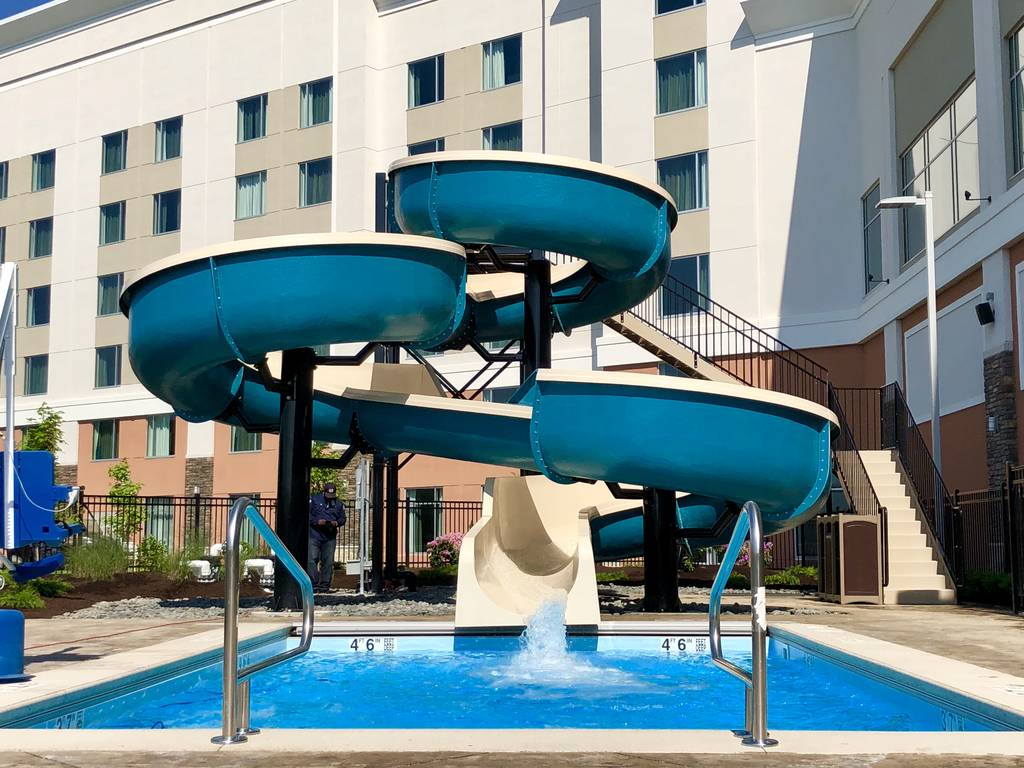 A pool with slides and water slide in the middle of it
