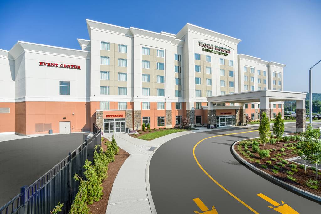 A hotel with a lot of parking spaces and trees
