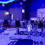 A table set up for an event with blue lighting.