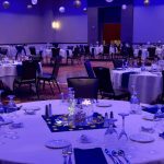 A banquet hall with tables and chairs set up for an event.