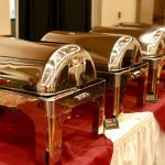 A row of silver trays on top of a table.
