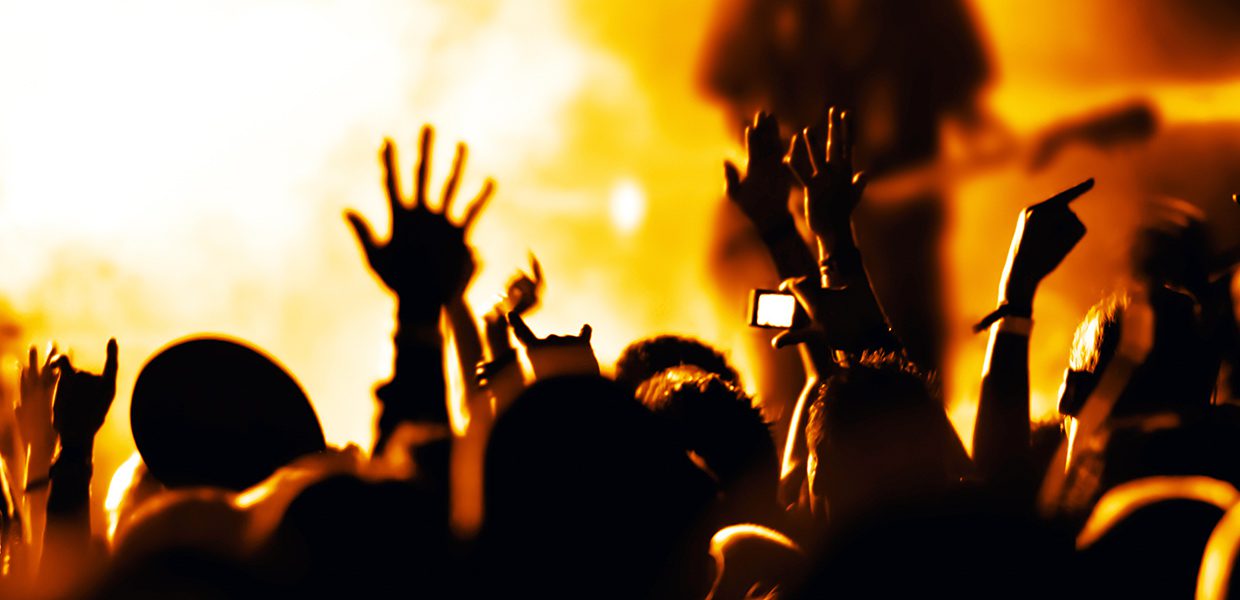 A crowd of people with their hands up in the air.
