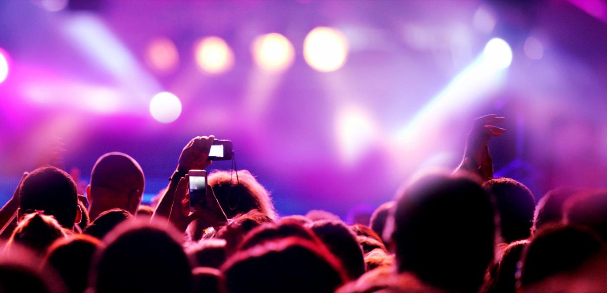A person taking a picture of an event with their phone.