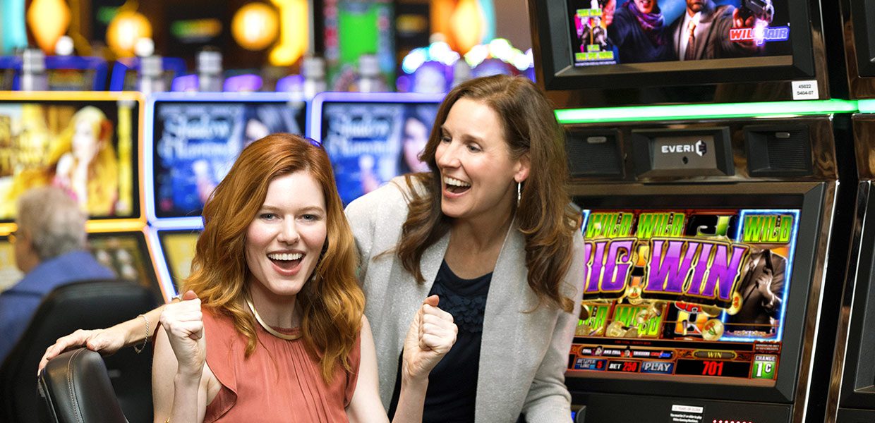 Two women are laughing in a casino.