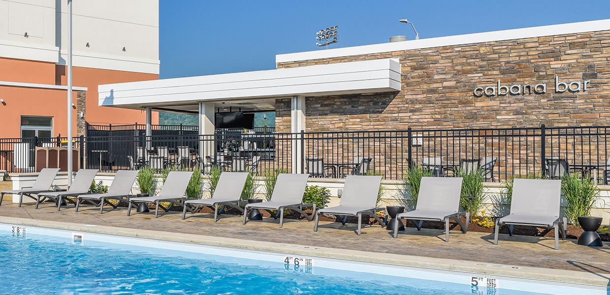 A row of lounge chairs in front of the pool.