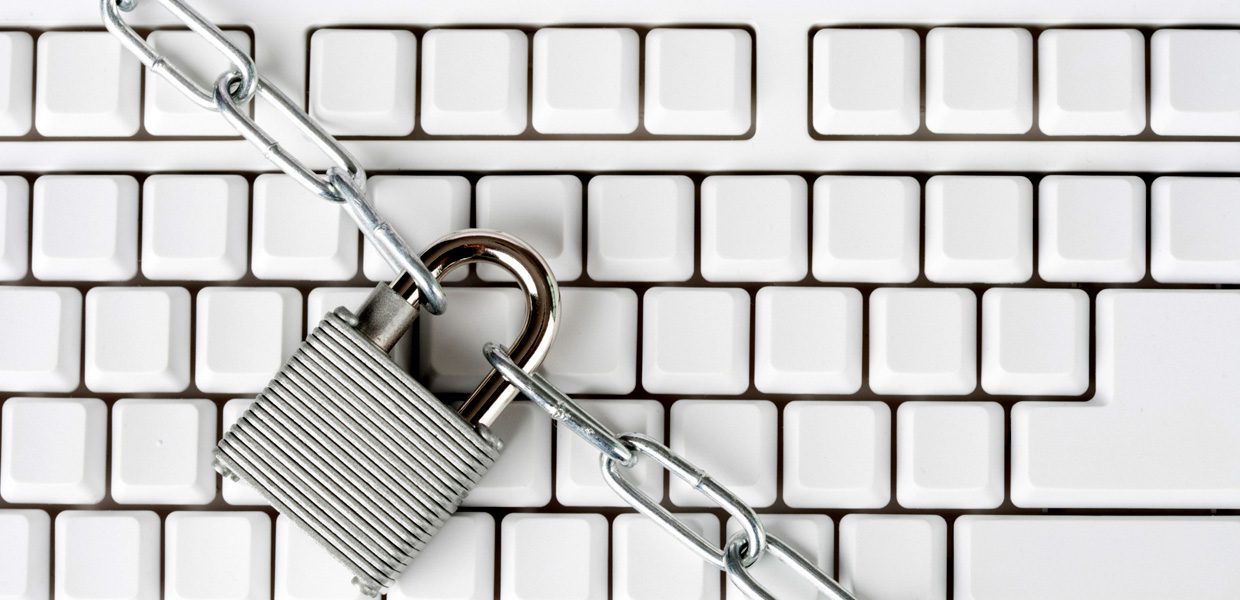 A padlock and chain on top of a keyboard.