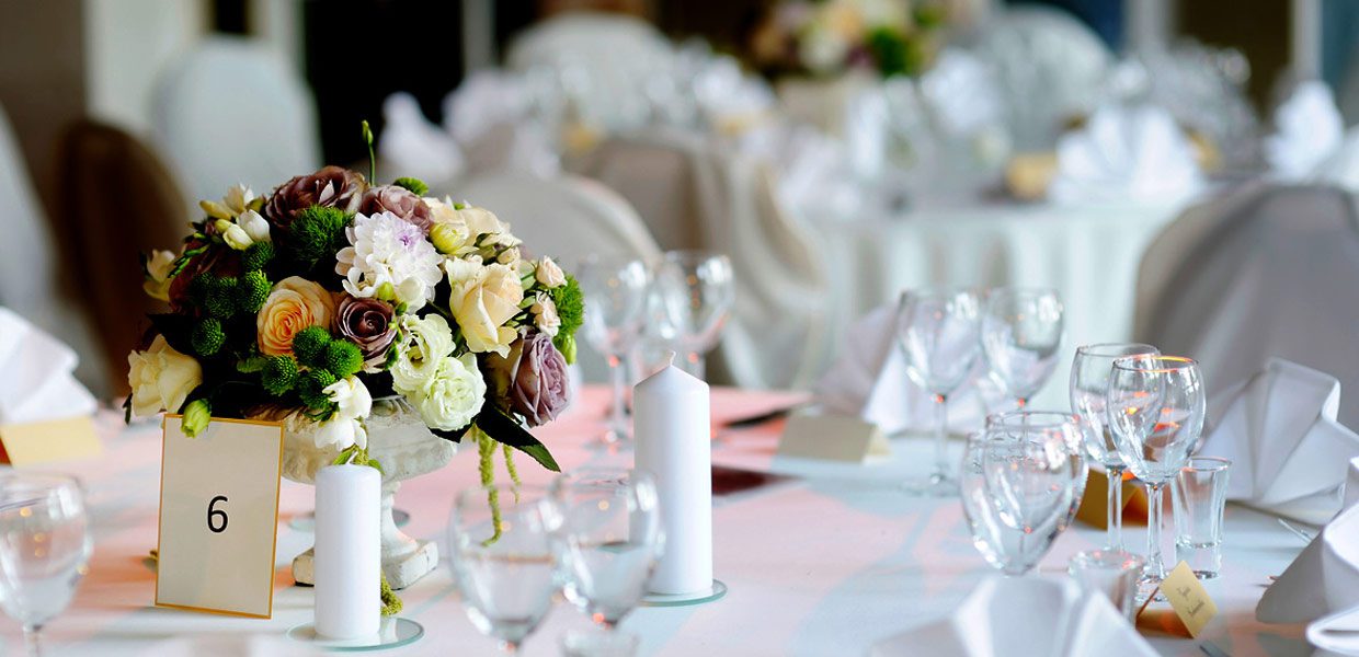 A table set with white plates and glasses