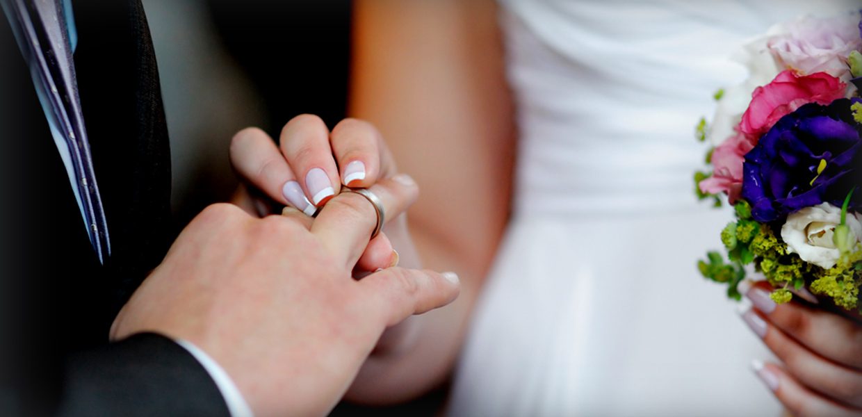 A man putting a wedding ring on his finger
