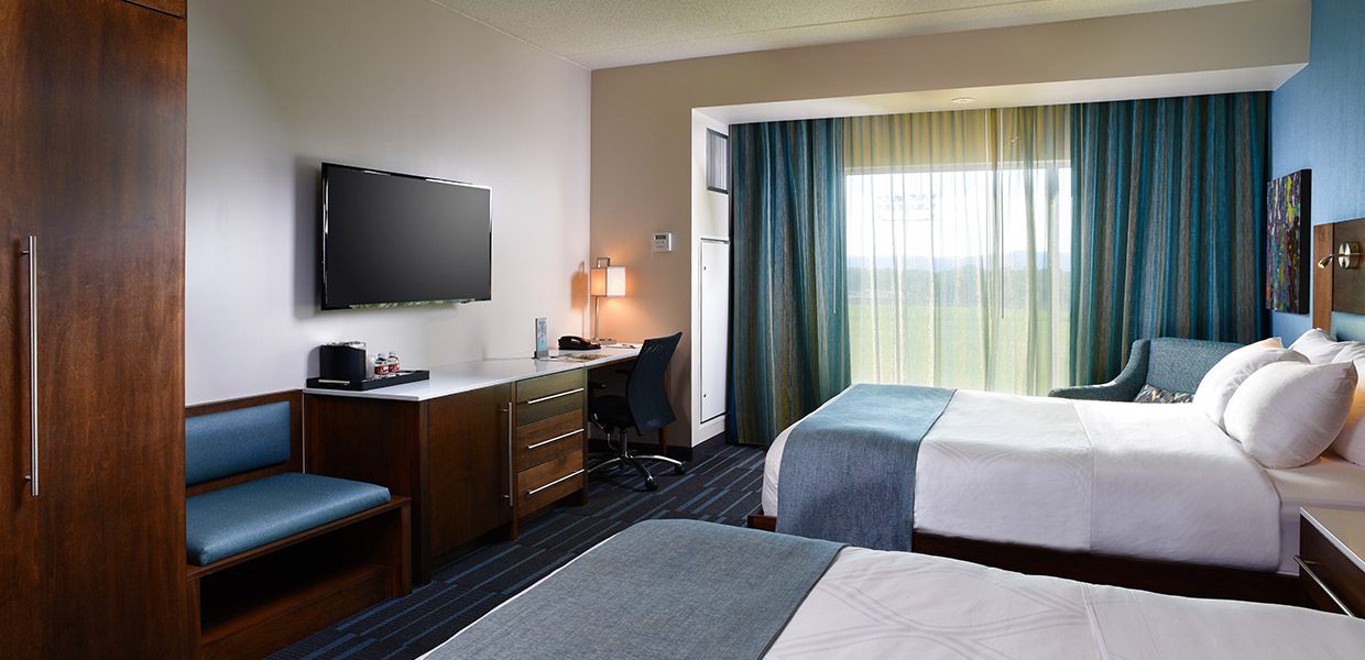 A room with two beds and a desk in it