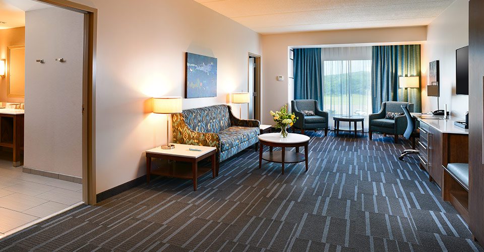 A living room with blue carpet and two tables