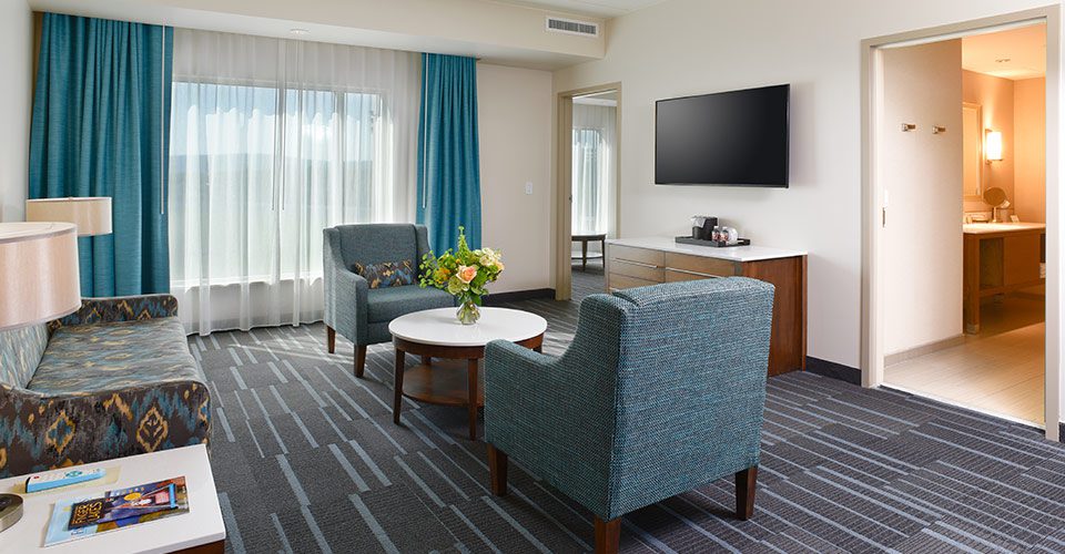 A living room with two chairs and a television.