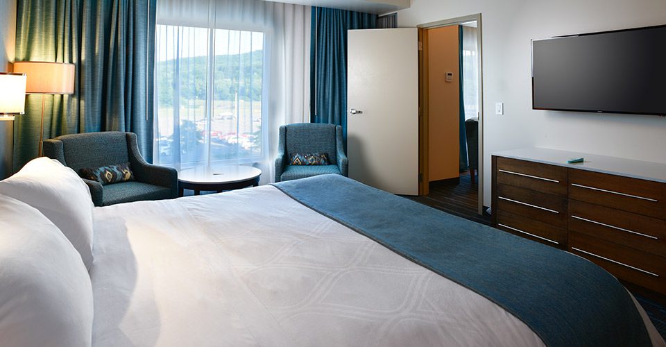 A bedroom with a large bed and chair in it