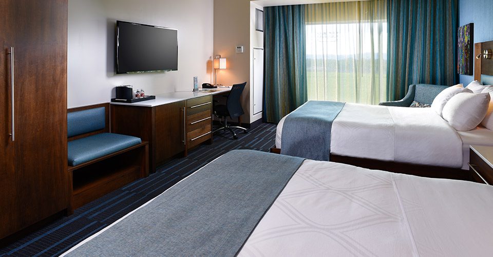 A room with two beds and a desk in it