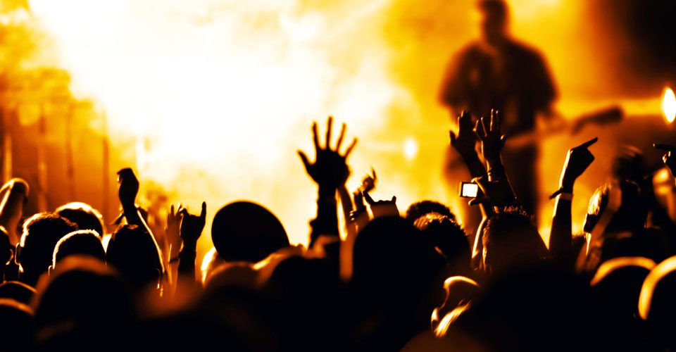 A crowd of people with their hands in the air.